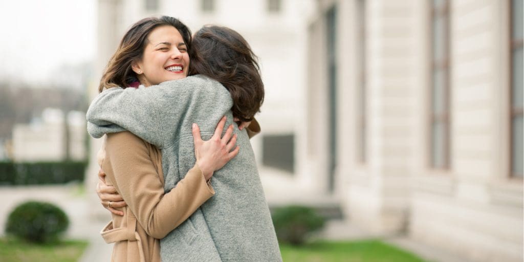 A woman, wondering how to get out of a depressive episode, hugs her friend.