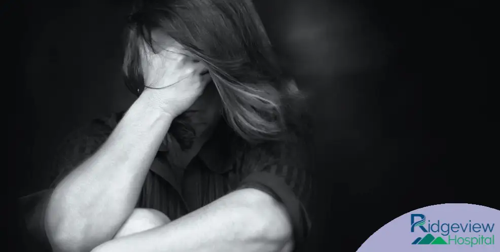 woman sitting down hands on the face - graphic